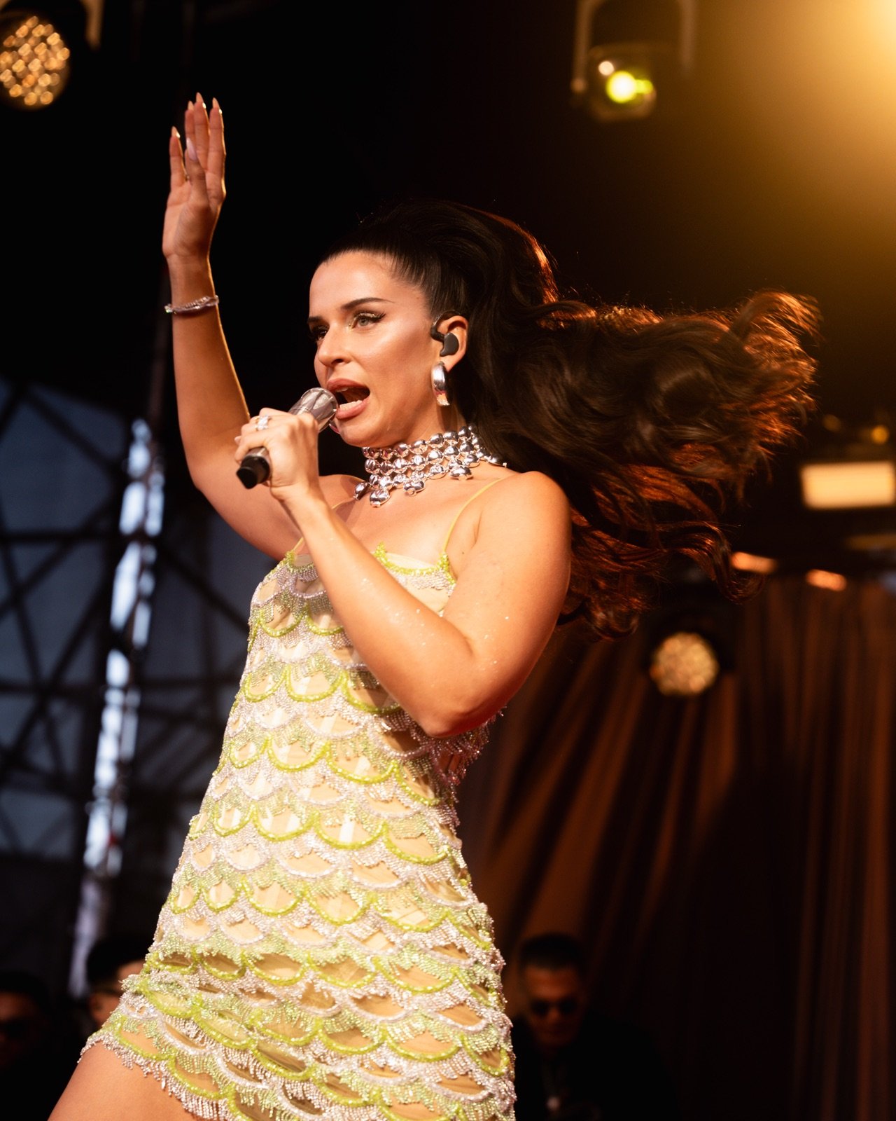 Nathy Peluso con vestido dorado y los brazos abiertos