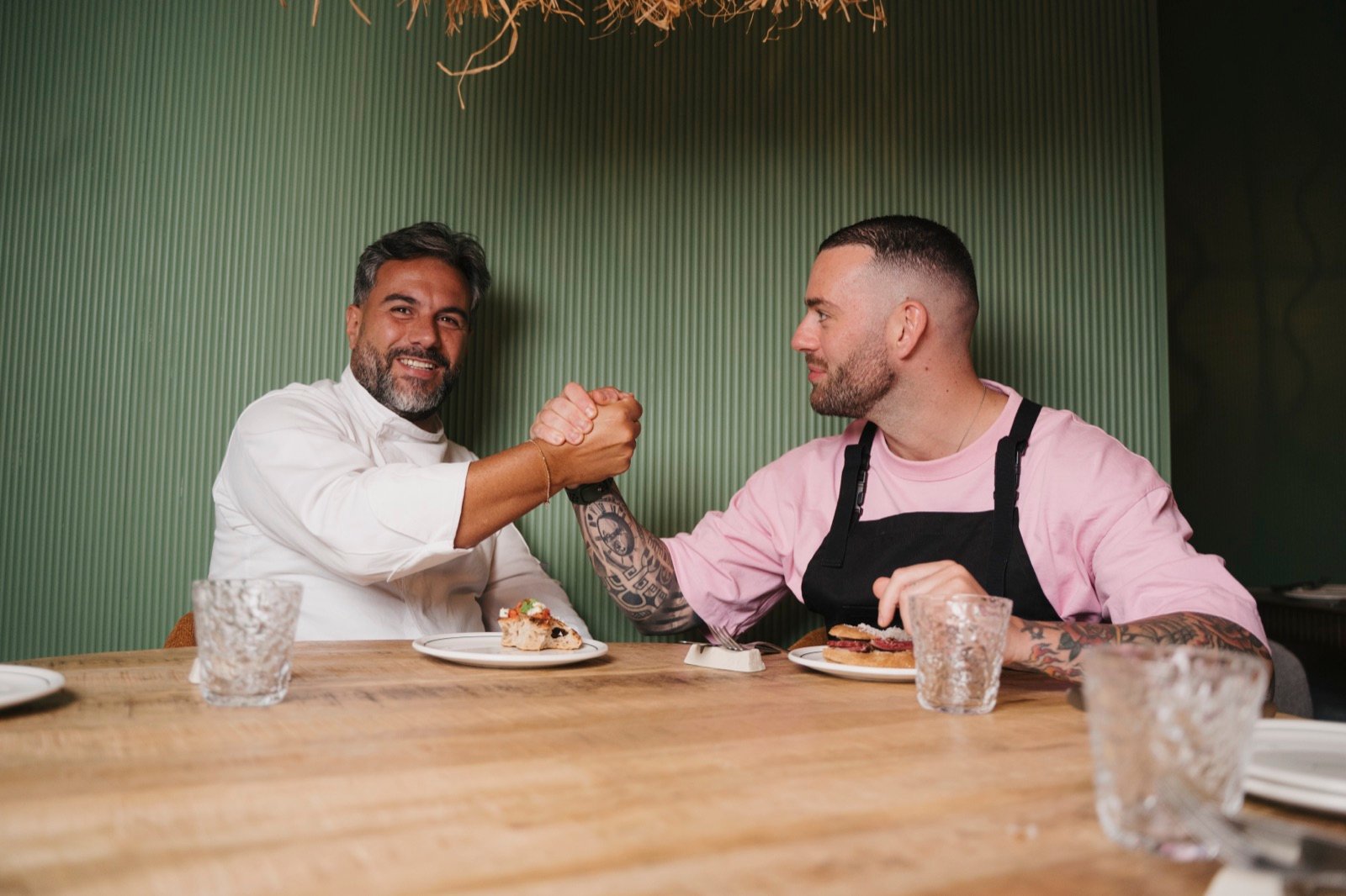 Los chefs chocando la mano en la mesa